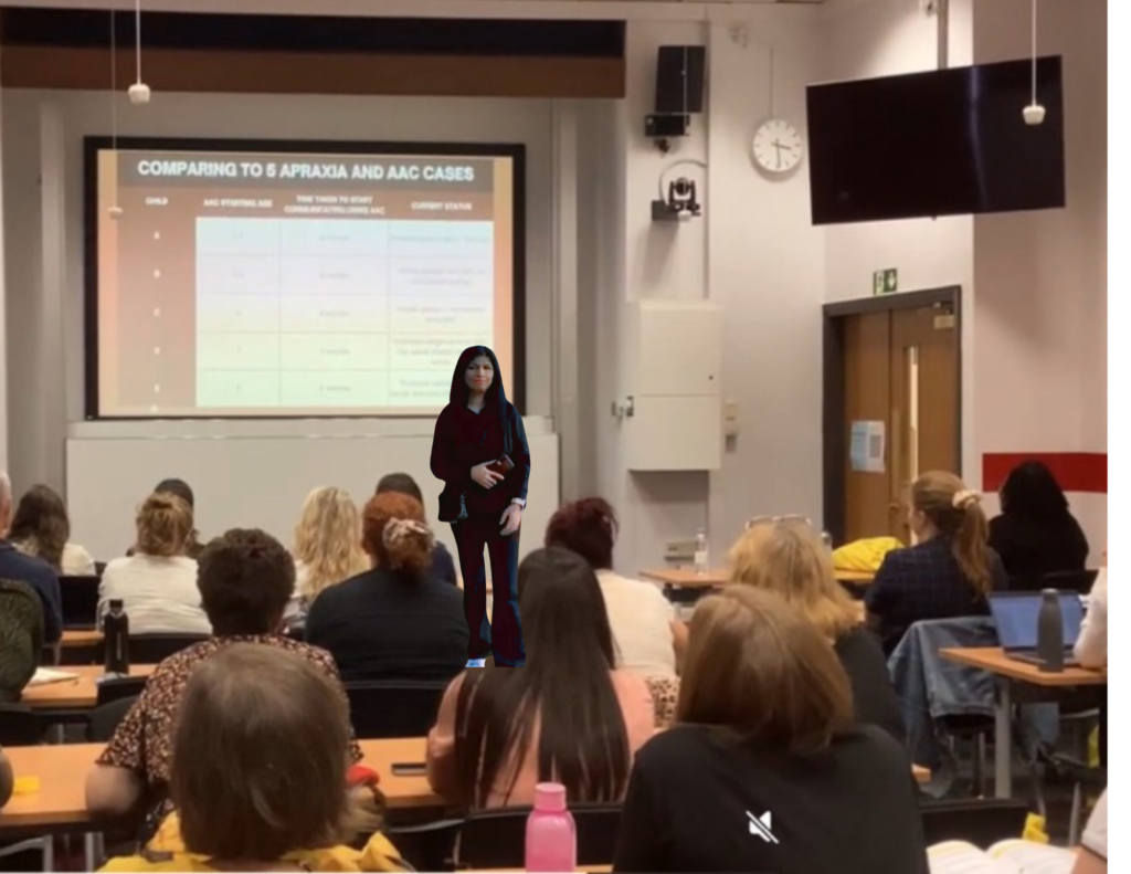shabna presenting paper at leeds university standing inforn tof the audience and =talking